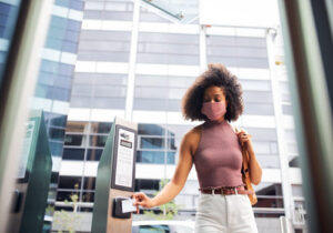 businesswoman-in-face-mask-swipes-security-pass-ou-2023-11-27-05-10-40-utc